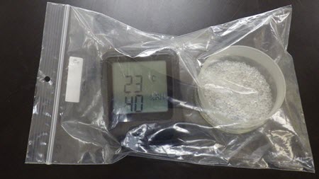 Compact hygrometer and sorbents in a polyethylene bag.