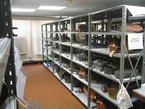 Metal shelving unit with five levels contains evenly spaced objects.