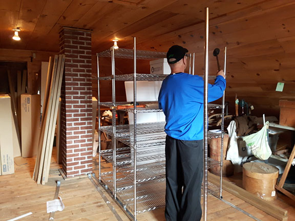 Man installing new compact wire shelving in MacLeod’s General Store