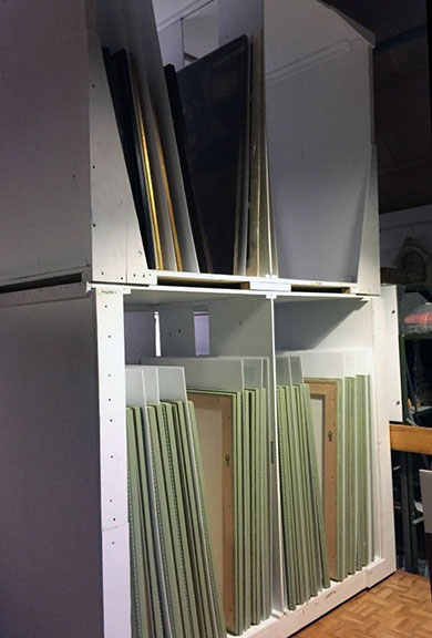 Framed works grouped together in a custom storage unit after RE-ORG