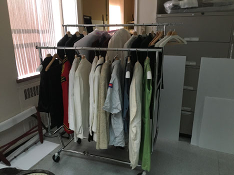 Costumes hung on garment racks after RE-ORG