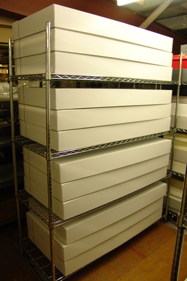 Storage of textiles in boxes placed on the new compact shelving units in storage room after RE-ORG