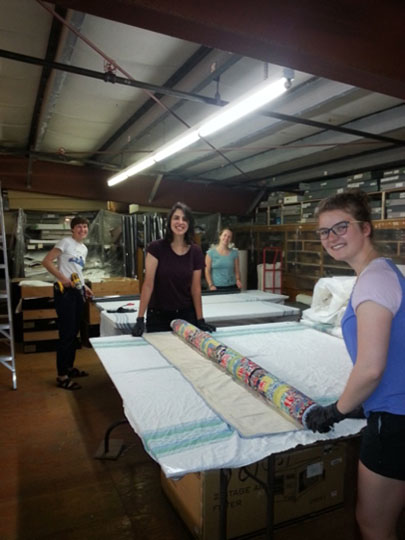 Rolling flat textiles in preparation for a hanging rolled system during RE-ORG
