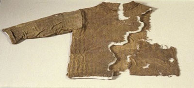 La veste issue des fouilles après le traitement et sur son support.