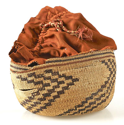 A broken twined basket made of spruce or cedar root.