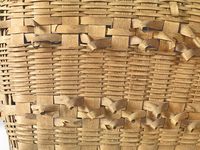 Quelques boucles décoratives en éclisses de bois ornant ce panier sont brisées ou manquantes.