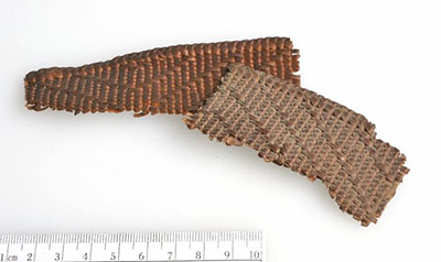 Two basketry fragments. One is covered in a layer of dust, which makes it look slightly grey.
