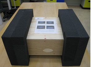La boîte est encastrée dans deux blocs creux et rectangulaires en mousse absorbante afin que l'objet soit protégé des chocs et des vibrations pendant le transport.