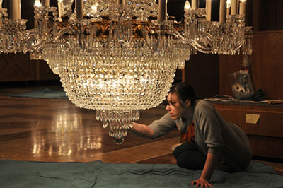 A woman carefully dismantles a regency-period (1844) lead crystal glass chandelier from the West Block, Parliament Hill, Ottawa.
