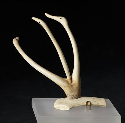 An antler sculpture of three geese is secure on its display mount.