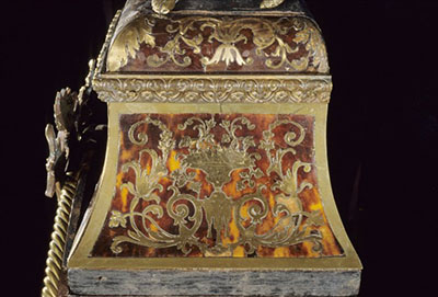 Side view of a clock showing marquetry made of brass and tortoiseshell known as “Boulle work”.