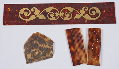Unpolished natural tortoiseshell compared to two examples of plastic imitations: a sample of marquetry work and a comb with its slip-in case.