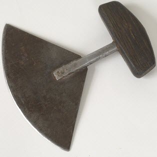 Un couteau inuit (« ulu »), fait de fer et muni d'une poignée en bois.