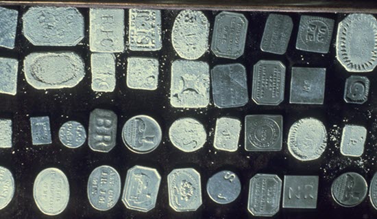 Lead and pewter medallions and tokens with corrosion.