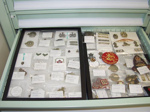A baked enamel metal cabinet, with metal objects inside bags, placed on foam liner padding.