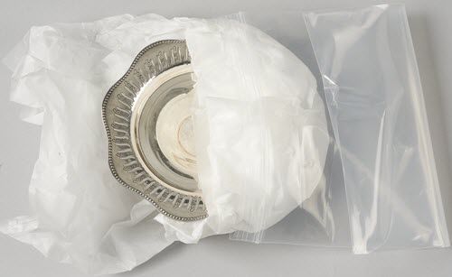 Silver item, tissue paper and a polyethylene bag.