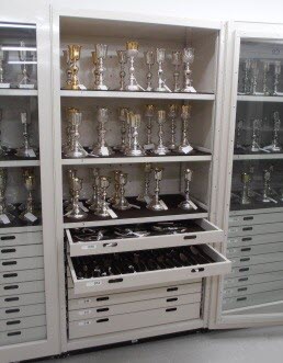 Opened door and drawers of a silver storage cabinet.