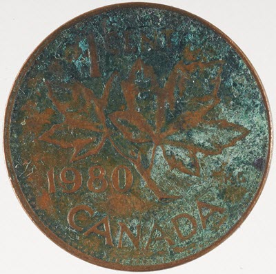 Penny with green, brown and black surface corrosion.