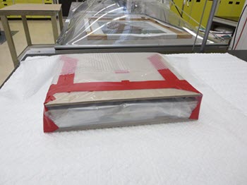 Un emballage en polyéthylène enveloppant entièrement le tableau maintient les cartons bien en place.