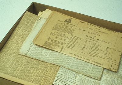 Box of discoloured newspapers.