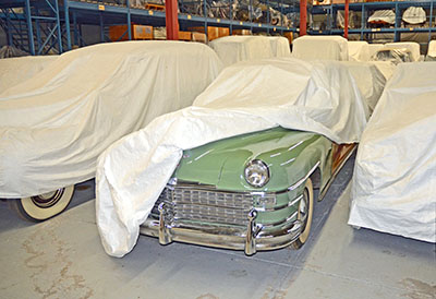 Des voitures d'époque dans une réserve, protégées par des housses antipoussière faite de non-tissé de polyéthylène (Tyvek).