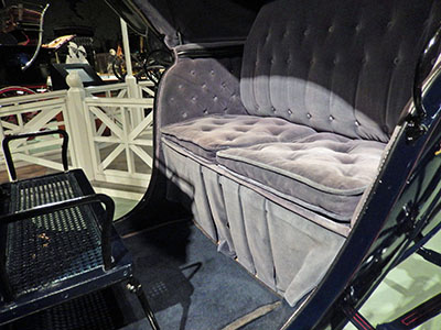 Velvet upholstery fabric on a carriage shows damage due to excessive exposure to sunlight and appears greyish-mauve in colour.