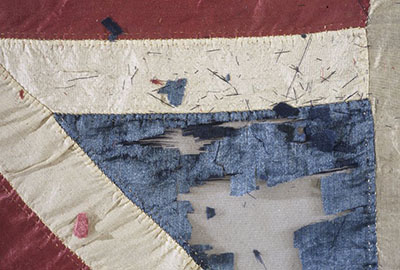 Detail of deteriorated weighted silk flag.