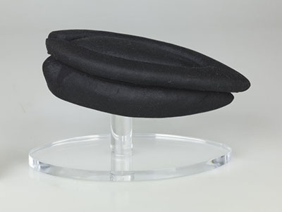 Support pour chapeau composé de deux morceaux de mousse matelassés et recouverts d’un tissu en tricot.