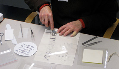 Workshop participant using the Dutch migration test papers and sponge-blotter system to monitor and control moisture levels while performing a remoistenable tissue repair on a didactic iron gall ink document