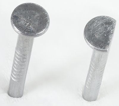 Two iron nails, head of nail on the right filed down so that the edge is flush with the shaft of the nail