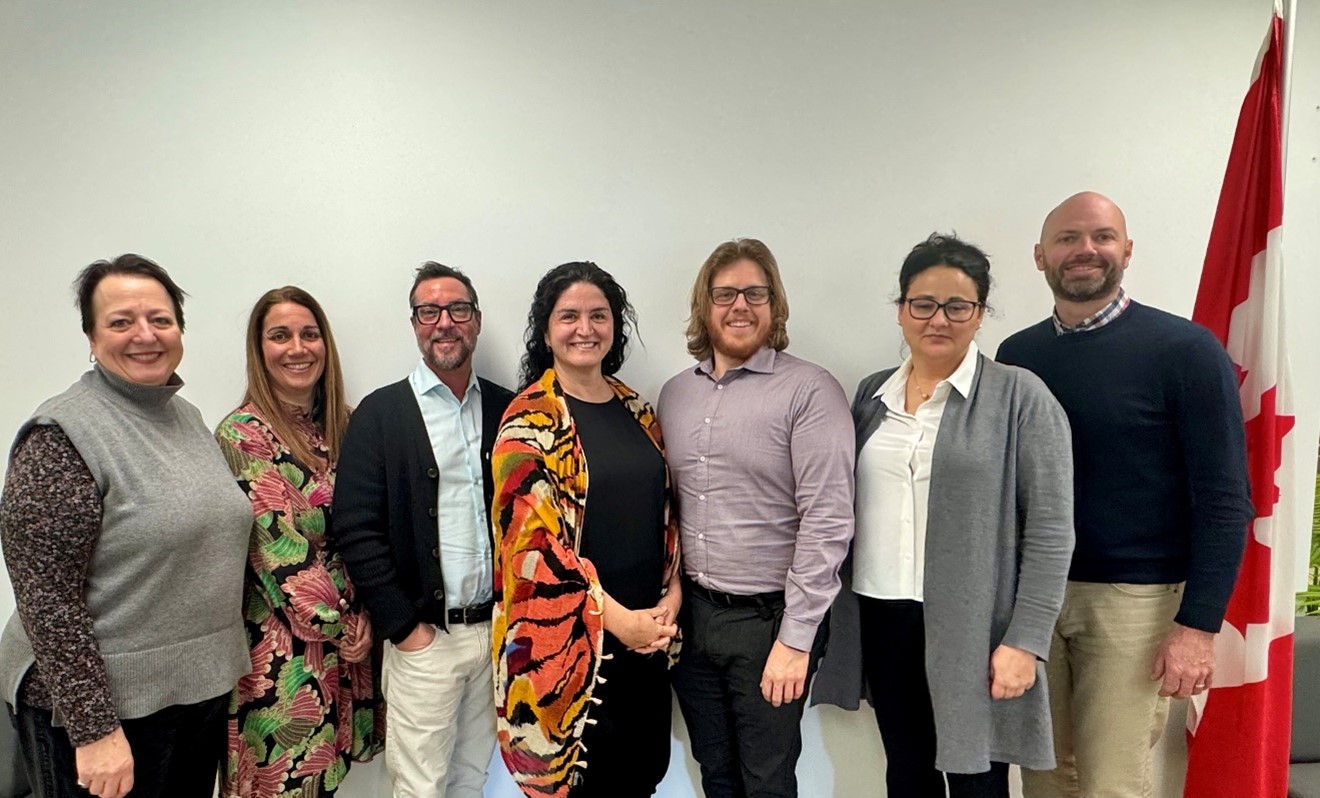 Photo of the Mauricie Business Office team standing in front of a wall, with a Canadian flag.