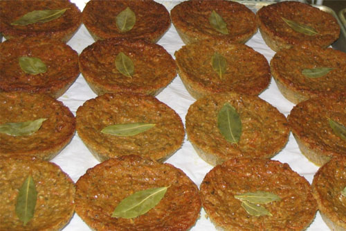 Pâtés végétariens alignés sur une plaque, avec une feuille de laurier au centre de chaque pâté.