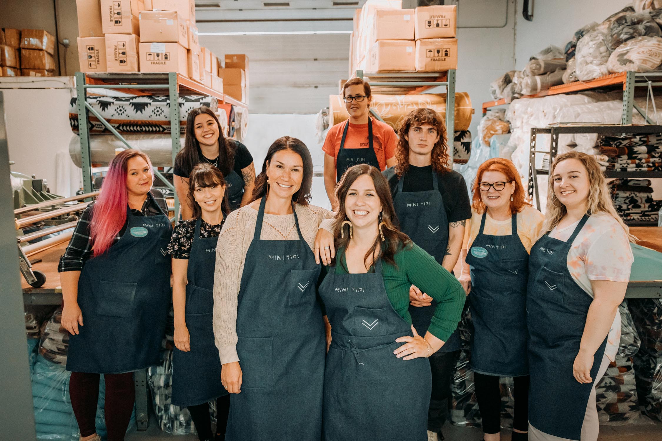 The entire MINI TIPI team is gathered for a photo in the production workshop.