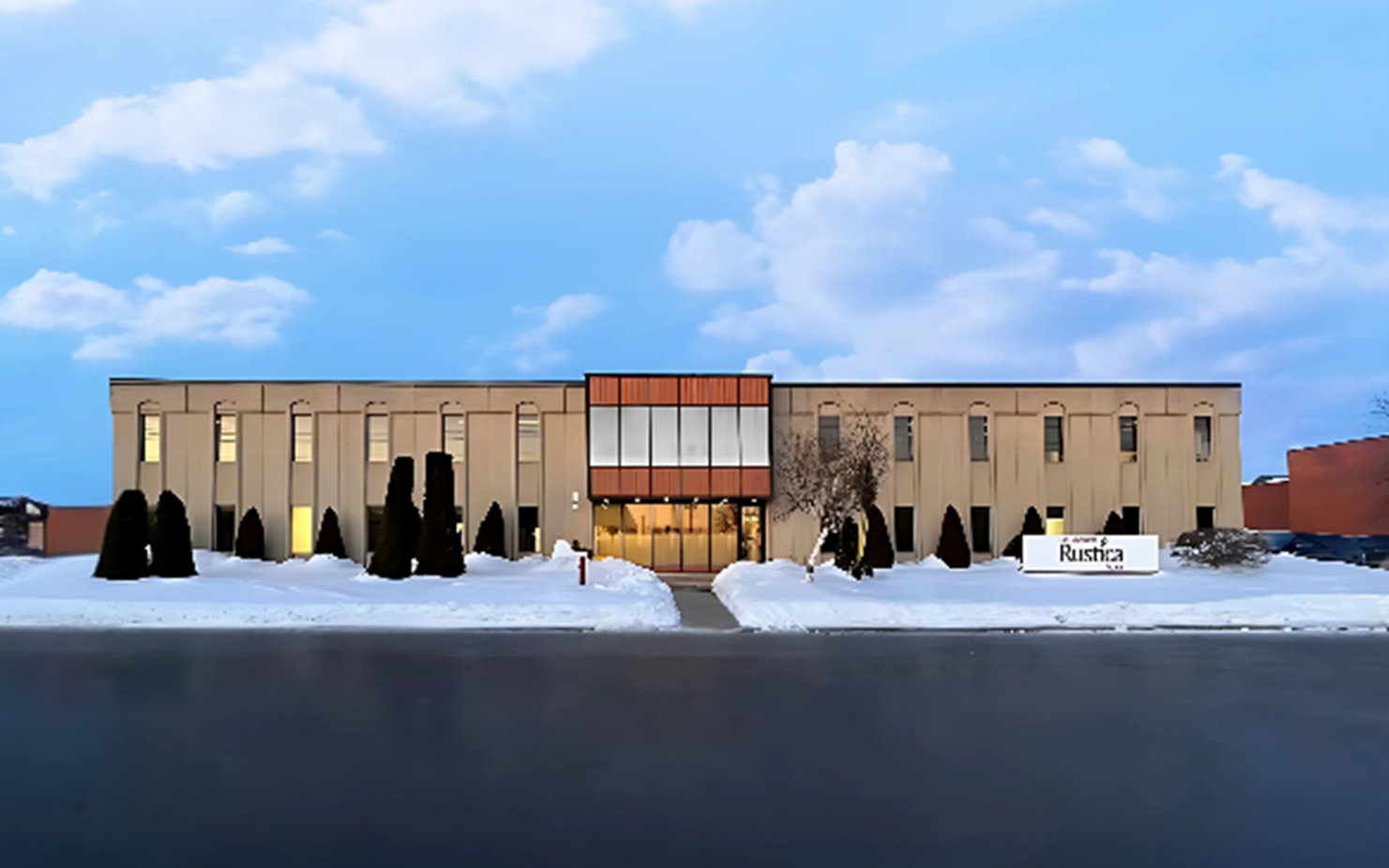 Rustica Foods’ head office viewed from the outside in winter, surrounded by snow and trees.