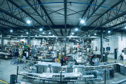 Vue d’ensemble de l’atelier de production avec machines et postes de travail.