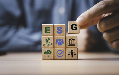 One hand holds dominoes representing environmental, social and governance factors.