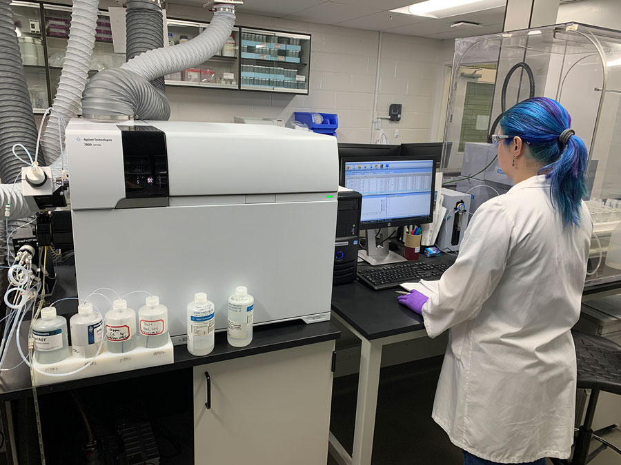 Lab technician operating an inductively coupled plasma mass spectrometry machine.