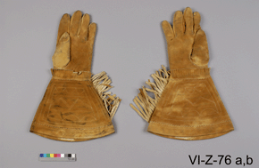 Photo of tan leather gloves, reverse view, with catalogue number VI-Z-76 a,b on a grey background.