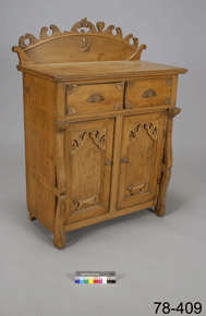 Colour photo of a wooden piece of furniture with drawers and cupboards, with catalogue number 78-409 on a grey background.