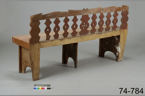Photo couleur d'un banc en bois avec des pieds en trois sections et un dossier décoré, avec un numéro de catalogue : vue arrière, 74-784 sur un fond gris.