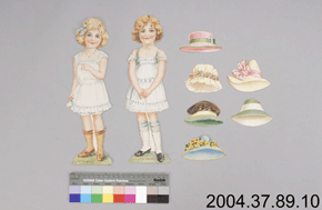Front view of two paper dolls, six paper hats, and catalogue number: 2004.37.89.10