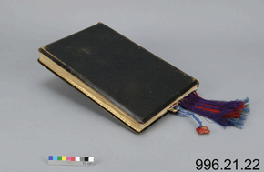 Reverse view of a black leather book with a scale and the number 996.21.22