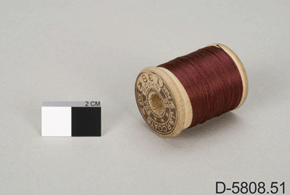 Colour image of thread spool with burgundy thread, 2 cm scale and  D-5808.51