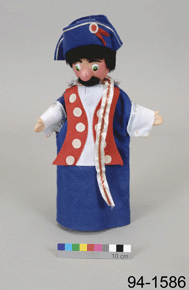 Colour photo of fabric-made hand-puppet with blue, red, and white colonial-era costume with colour scale and the number 94-1586