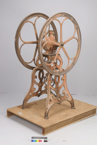 Colour photo of copper coloured metallic device with large wheels, with catalogue number F-10552 on a grey background.