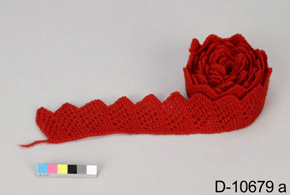 Colour photo of a partially rolled piece of red knitted material, with catalogue number D-10679 a on a grey background.