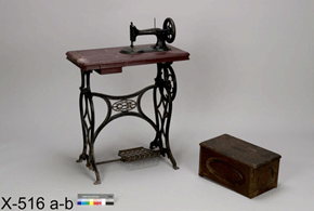 Colour photo of a mechanical foot-powered sewing machine with box covering adjacent, with catalogue number X-516 a-b on a grey background.