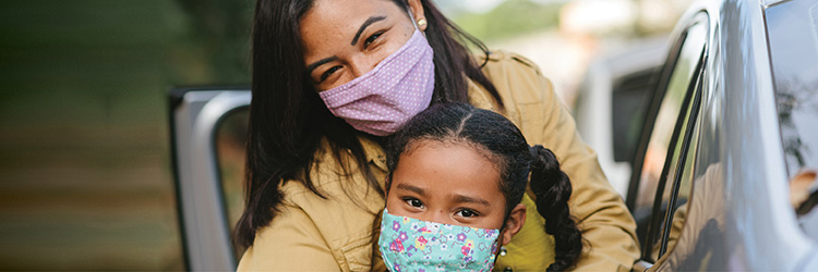 Adult and child wearing masks while outdoors