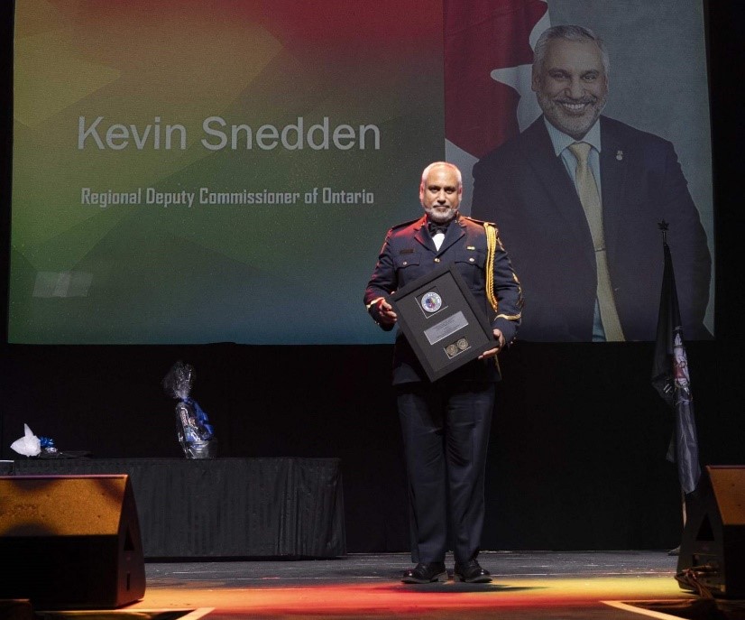 Kevin Snedden tient son prix sur une scène