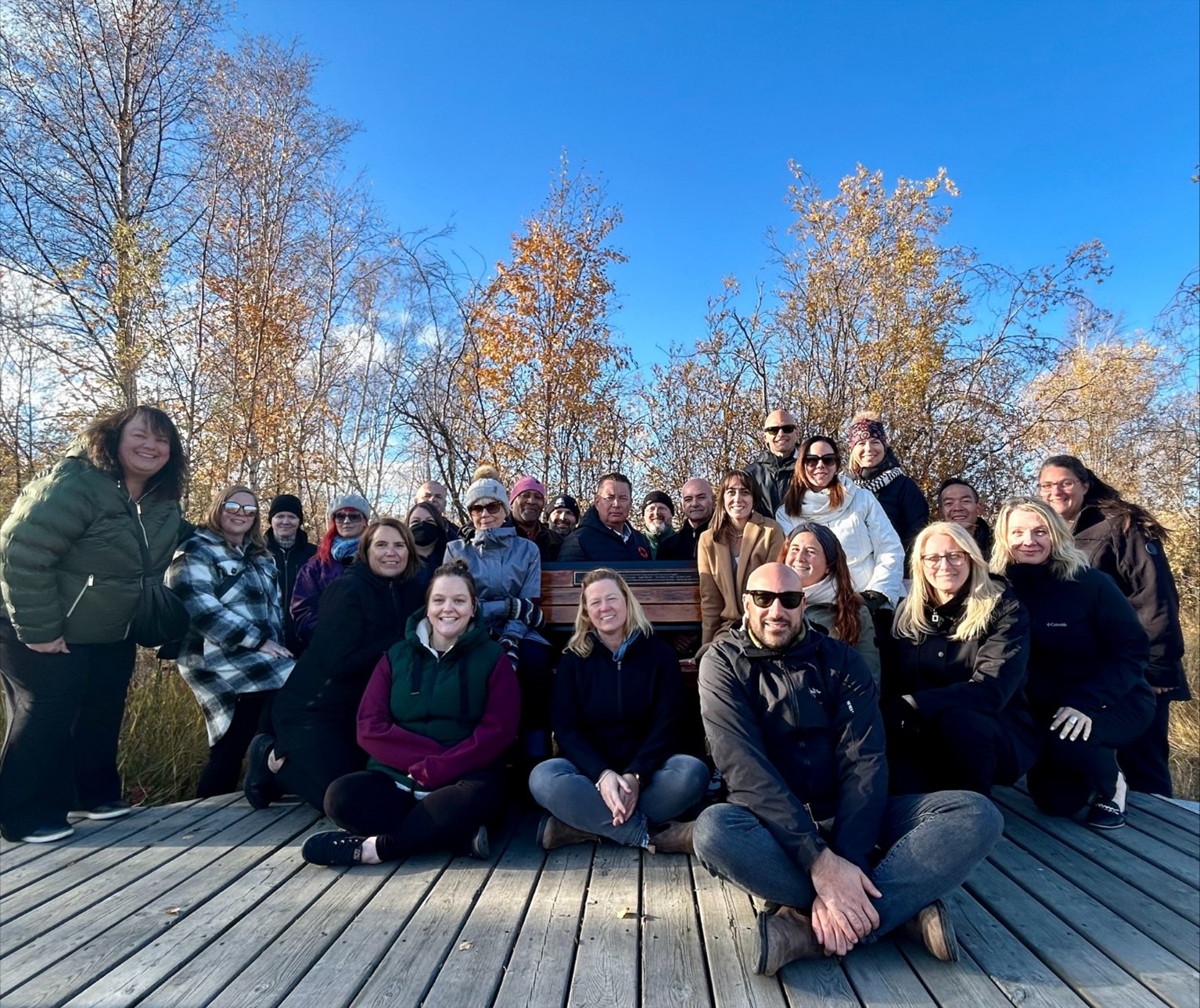 group photo of the Advisory Committee on Community Safety and Operations members sitting on and around the memorial bench